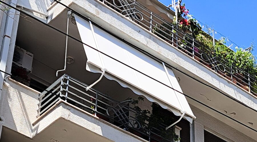 Εικόνα κλασικής τέντας με αντιρίδα χρώματος εκρού.